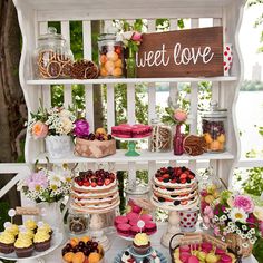 a table topped with lots of cakes and desserts