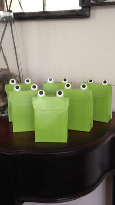 green bags with eyeballs on them sitting on a table