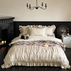 a bed with white comforter and pillows in a room next to a chandelier