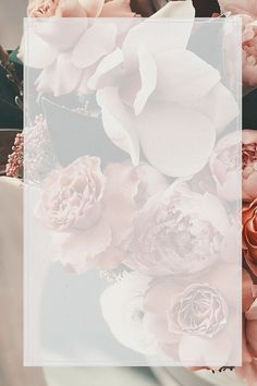 a bouquet of flowers sitting on top of a table next to a white square frame