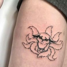 a small tattoo on the leg of a woman's thigh, depicting a cat