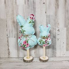 two small wooden bunnies with flowers on them