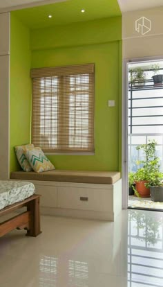 a bedroom with green walls and white tile flooring, along with a window seat