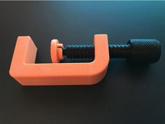 an orange and black object on a black surface with one end missing from the handle