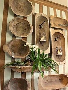 several wooden bowls and spoons are hanging on the wall with striped walls behind them