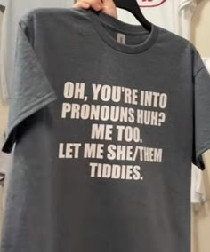 someone holding up a t - shirt that says oh, you're into pronouns nuh? me too let me she / them tidies