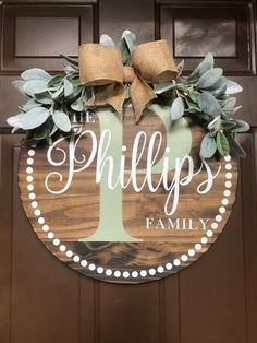 a wooden sign that says, phillips's family on it with a bow hanging from the front door