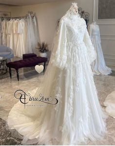 a white wedding dress on display in a bridal gown shop with mannequins