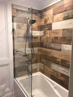 a bath tub sitting inside of a bathroom next to a walk in shower and tiled walls