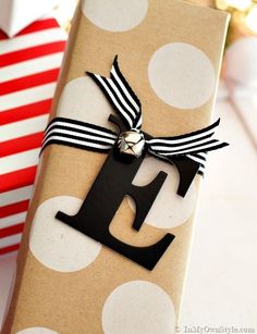 a gift wrapped in brown paper with a black and white ribbon tied around the letter e