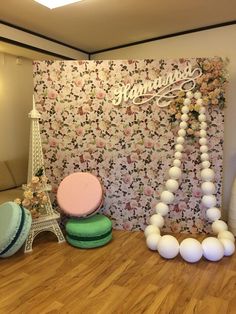 the eiffel tower is surrounded by balloons and other decorations in front of a floral wall