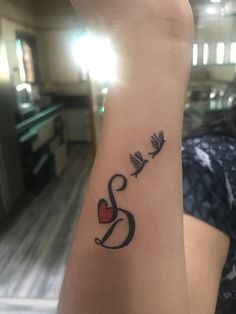 a woman's arm with a tattoo on it that reads love and two birds