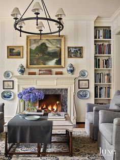 a living room filled with furniture and a fire place in front of a painting on the wall