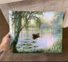 a person holding up a painting of a boat in the water with lily pads on it