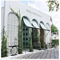 the entrance to mallounfing's is decorated with green and white shutters