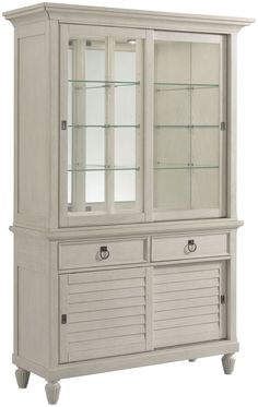 a white china cabinet with glass doors and shutters on the bottom, two drawers