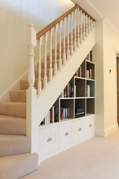 a staircase with bookshelves and drawers in a room that has carpet on the floor