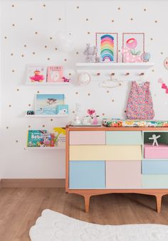 a child's room with pink, yellow and blue drawers