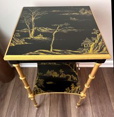 a black and gold table with a painting on it