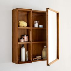 an open medicine cabinet with soaps, lotion and other items on the shelf