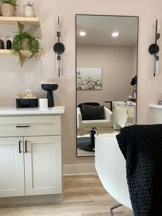 a salon with chairs, mirrors and plants on the wall in front of it's mirror