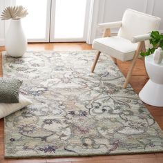 a living room area with a rug, chair and potted plant