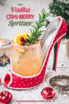 a red high heel shoe sitting on top of snow covered ground next to a christmas tree