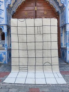 an area rug is placed in front of a door with blue and white tiles on it