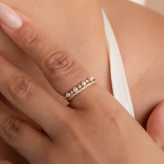 a woman's hand with a ring on her left side and two diamonds on the middle