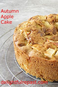 an apple cake on a wire rack with the words, autumn apple cake below it