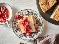 a piece of cake on a plate with strawberries next to it and a bowl of fruit