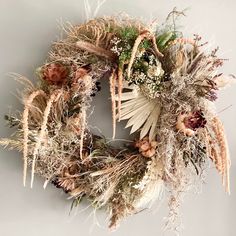 a wreath with dried flowers and plants on it