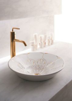 a white bowl sink sitting on top of a counter next to a faucet