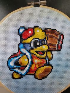 a cross stitched picture of a teddy bear