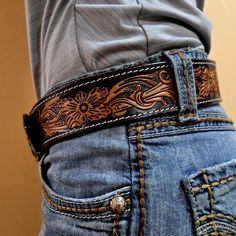 The Maverick Western Leather Belt: Bold Style for the Rodeo Cowboy Channel your inner cowboy with the Maverick Western Leather Belt, a perfect blend of rugged style and artisan craftsmanship. This premium belt features a hand-carved scrolling design, meticulously crafted by skilled artisans, making it a standout piece for any rodeo, ranch, or casual outing. Designed for him or her, this versatile Western belt is a must-have for anyone who values quality and timeless style. Features That Set This Belt Apart: Hand-Carved Scrolling Design: A bold, intricate pattern that embodies the Western spirit and adds an authentic touch to your outfit. Premium Leather Construction: Made from high-quality leather that's durable yet soft, offering comfort and long-lasting wear. Natural Dye Finish: Eco-frie Belts Outfits, Western Leather Belt, Handmade Leather Belts, Women's Western Wear, Belt Western, Rodeo Cowboys, Handmade Leather Belt, Kids Belt, Cowboy Belt