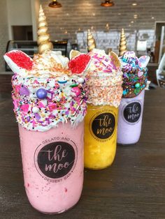 three unicorn milkshakes with sprinkles on them