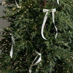 a christmas tree is decorated with lights and ribbons