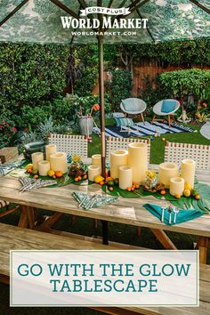 an outdoor table with candles and place settings on it in front of the words go with the glow tablescape