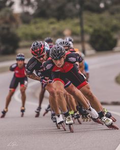 several people riding roller blades down a street in front of each other on skateboards