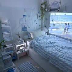 a bed room with a neatly made bed next to a window overlooking the beach and water