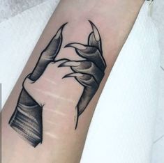 a black and white photo of a hand holding a book tattoo on the left arm