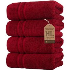 four red towels stacked on top of each other with a tag hanging from the front