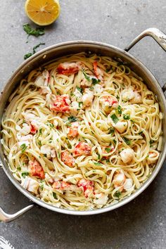 a pan filled with shrimp pasta and garnished with parsley on the side