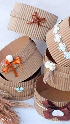 three cardboard boxes with ribbons and flowers on them