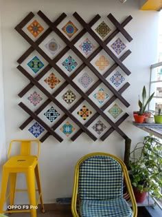 a chair and table in front of a wall with colorful tiles on it