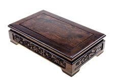 a small wooden box with carvings on the front and sides, sitting on a white surface