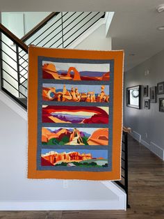 an orange and blue quilt hanging from the side of a stair case in a house