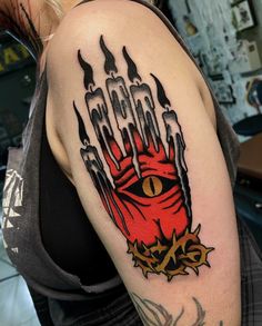 a woman with a tattoo on her arm has a red demon hand holding two candles