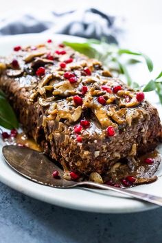 a white plate topped with brownies covered in nuts and pomegranates