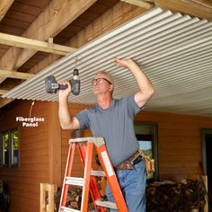 a man on a ladder working on a roof with a driller and lightbulb